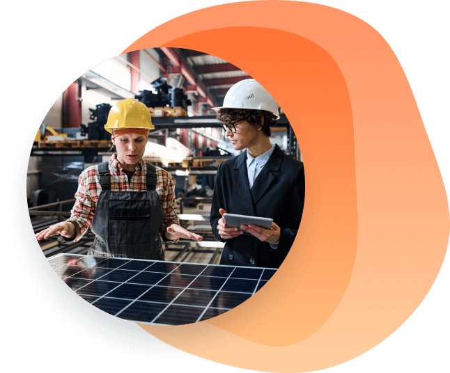 Two woman in safety helmets working on solar panels